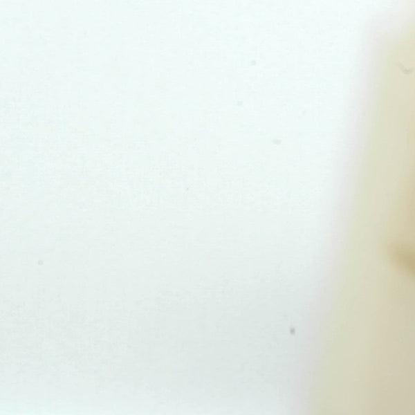 A closeup video of a man stamping on white paper, leaving the impression of line art of a nude Baba Yaga, grinning and riding her flying mortar and pestle, with a broom in hand.