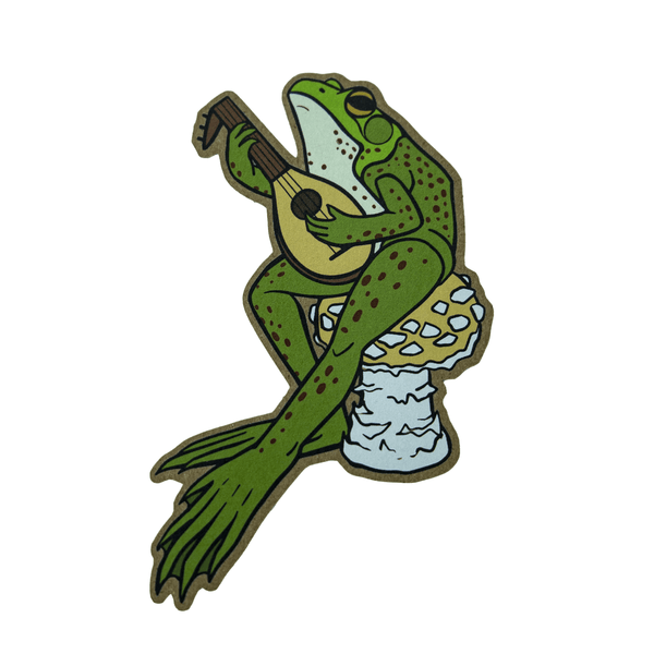 A brown kraft paper sticker of a green speckled Northern Frog playing a medieval stringed instrument while sitting on a golden agaric mushroom.
