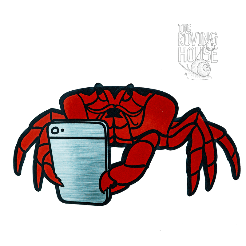 A vinyl sticker of a red Christmas island crab holding a metallic silver smartphone, with a surprised expression.