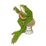 An enamel pin of a northern green frog sitting atop a golden agaric mushroom, strumming a medieval stringed instrument.