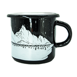 The reverse side of a black enamel and metal camp mug. The all-white design continues to wrap around the mug, with a snowy winter landscape, with pine trees, icy mountains, and a starry night sky in the background.